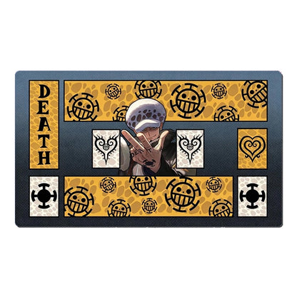 A rectangular anime-themed mat featuring One Piece character designs and the word 'DEATH' on a black background with yellow patterned sections.