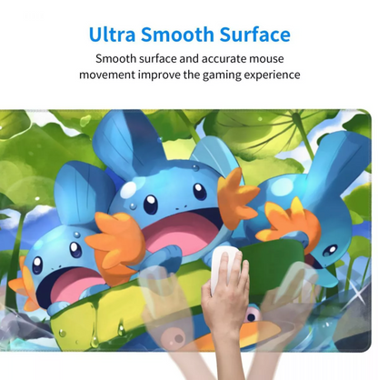 A colorful gaming mousepad featuring cartoon blue creatures with orange feet among green leaves, with a hand holding a white mouse on the pad. Blue text at the top reads, 'Ultra Smooth Surface Smooth surface and accurate mouse movement improve the gaming experience.