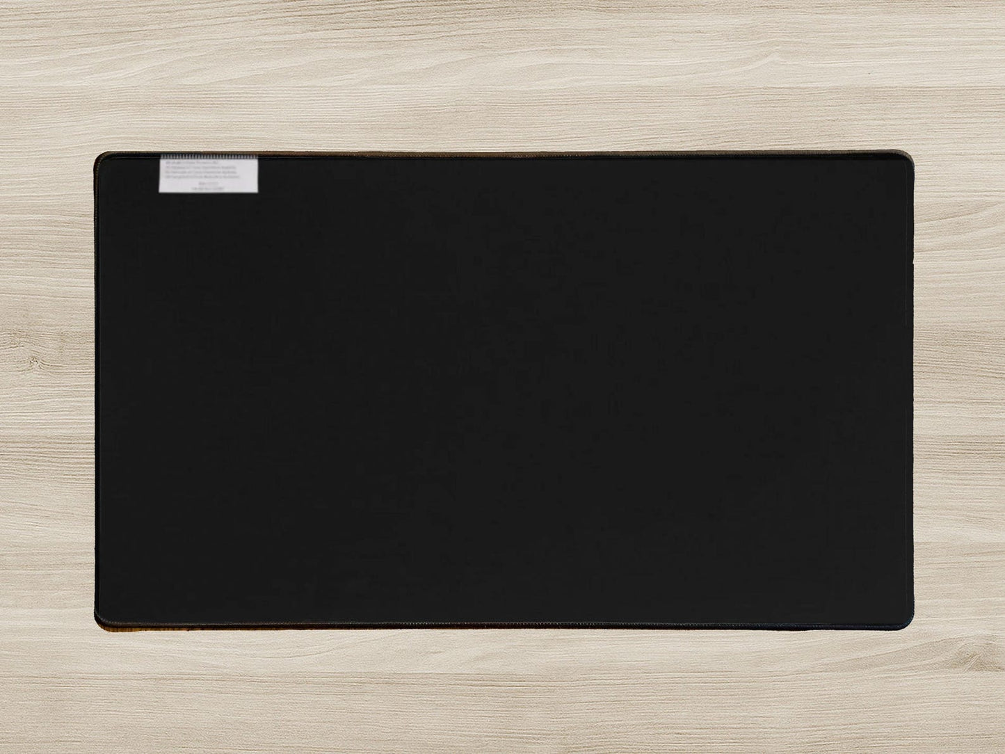 Black desk mat on a light wood surface