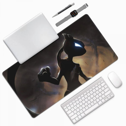 A large desk mat featuring a printed illustration of a dark fantasy character, shown in a styled flat-lay with a white laptop, keyboard, mouse, pen, and smartwatch on a light gray background.