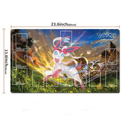 A Pokémon Trading Card Game playmat shown on a white background with printed dimensions and labeled card zones. The mat features a colorful fantasy scene with a white and pink Pokémon character in the center and the Pokémon logo in the top right.
