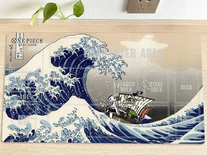 Decorative mat with a ship in a wave design on a wooden surface.