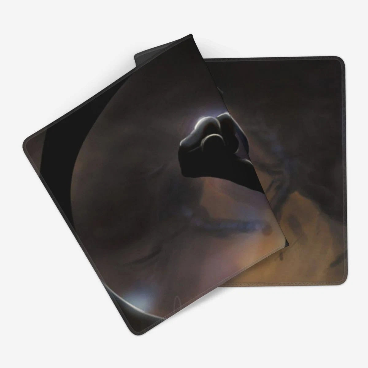 Two square mouse pads with rounded corners, featuring a dark sci-fi graphic of a fist reaching out against a smoky space background, displayed on a clean white background.