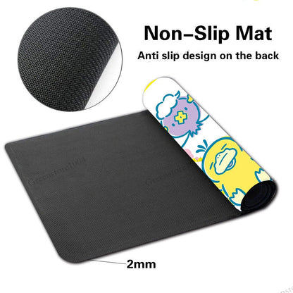 Black non-slip desk mat with a rolled-up section showing a colorful cartoon pattern on the underside, plus text reading 'Non-Slip Mat' and 'Anti slip design on the back' with a '2mm' thickness callout.