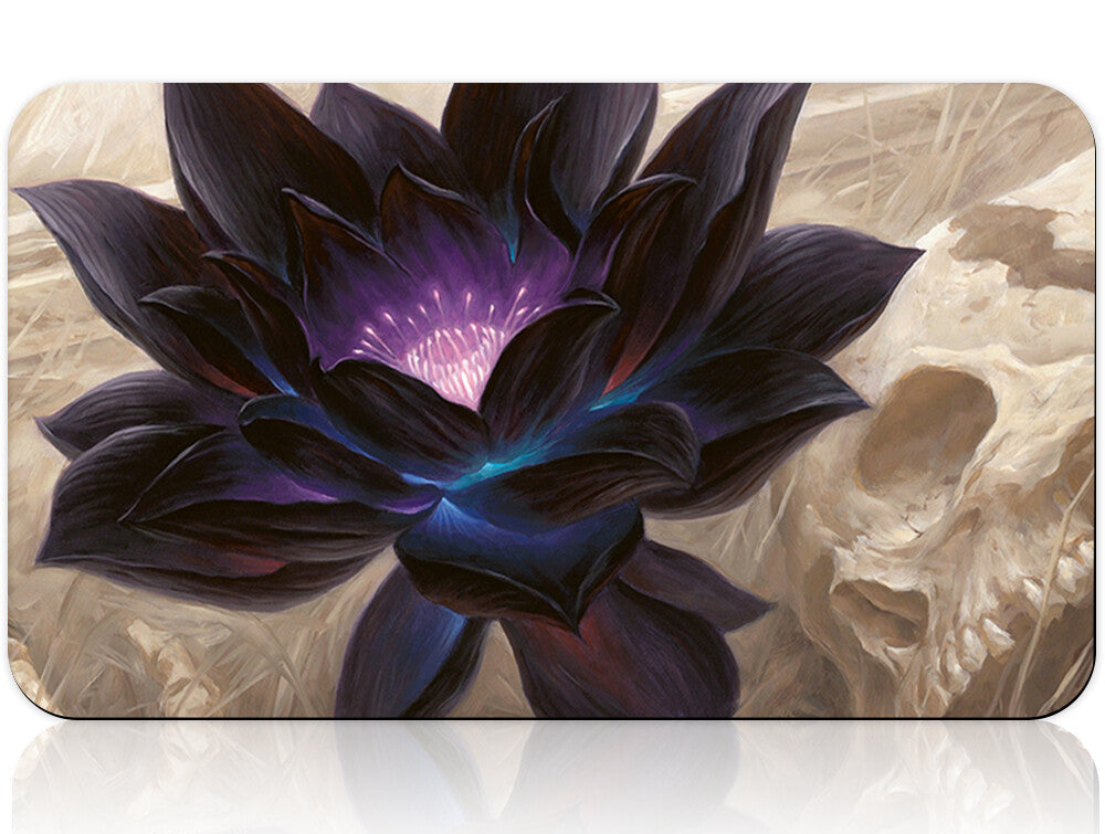 Black flower design on a product packaging with a silver tool below.