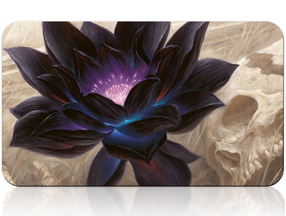 Black flower design on a product packaging with a silver tool below.