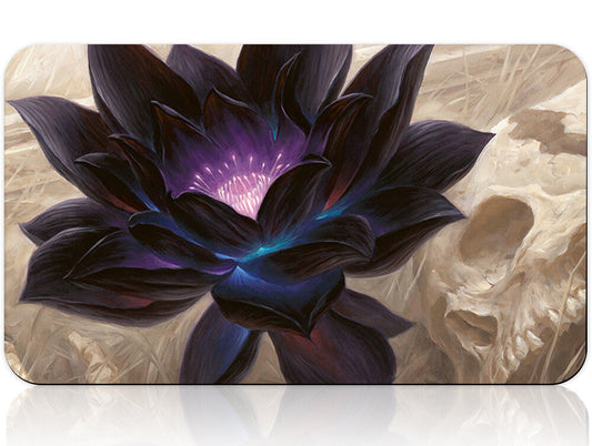 Black flower design on a product packaging with a silver tool below.