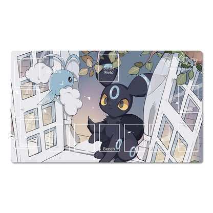 A rectangular gaming playmat featuring an anime illustration of a black cat-like character with yellow eyes and a blue crescent on its forehead, alongside a light blue creature with white clouds around it. The playmat is shown on a clean white background with subtle drop shadows.