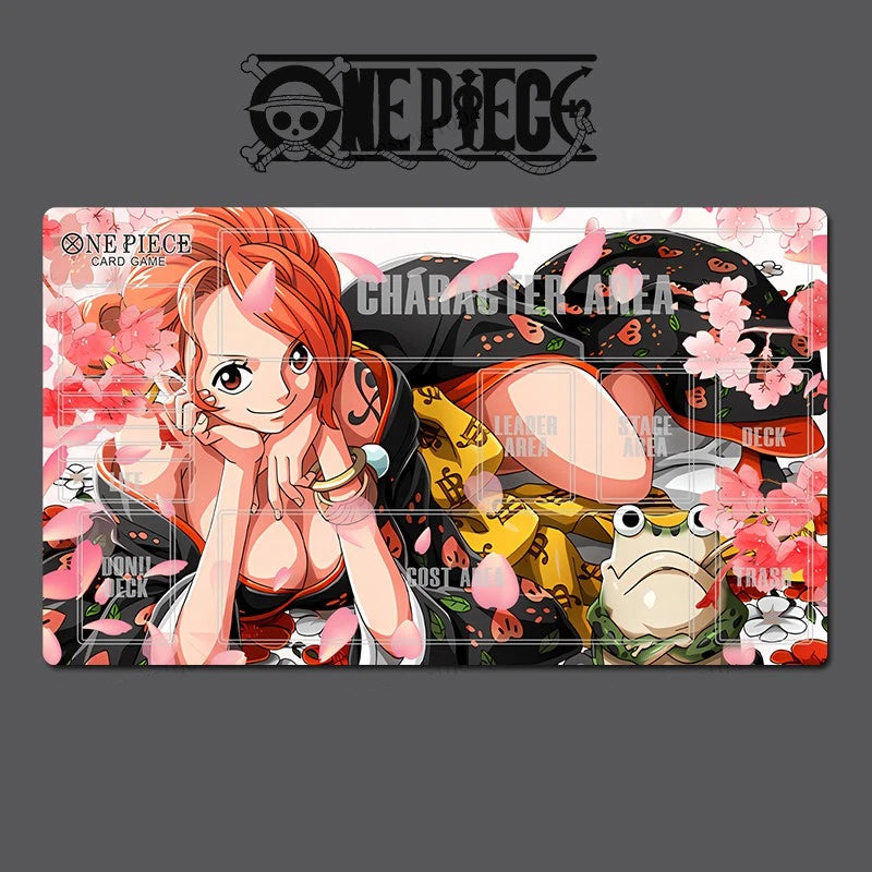 A One Piece character playmat featuring Nika Roronoa Zoro, with pink cherry blossoms, gold coins, and a frog illustration, shown on a dark gray background with the One Piece logo above.