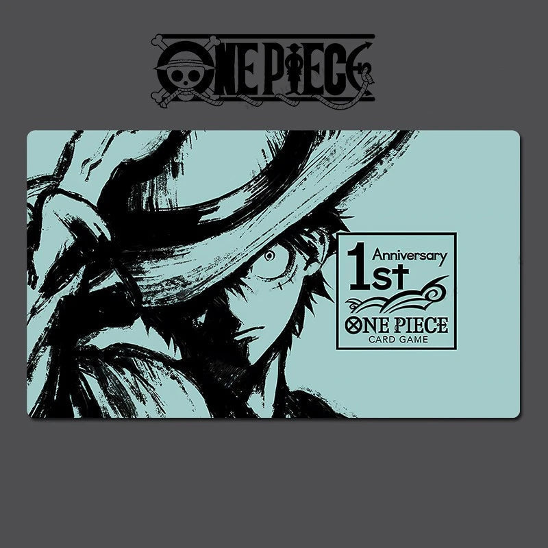 A One Piece 1st Anniversary card game card featuring a black ink illustration of a character on a light blue background, shown against a dark gray backdrop with the One Piece logo at the top.